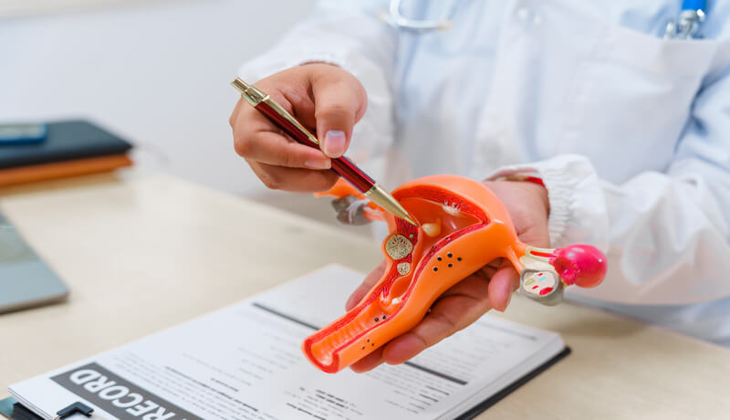 A doctor sits at a desk in hospital explains about uterine conditions