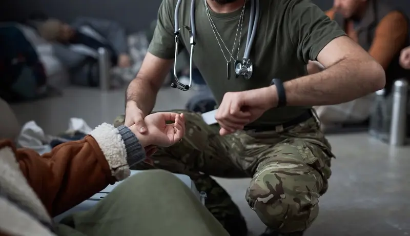 a doctor taking heart pulses from a patient by touch her hand