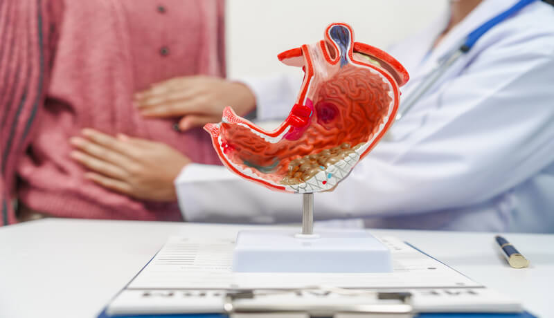 medical professional a stethoscope is holding a clipboard, possibly discussing gastritis