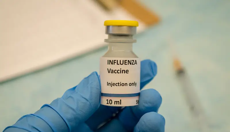 A doctor holding an influenza vaccine