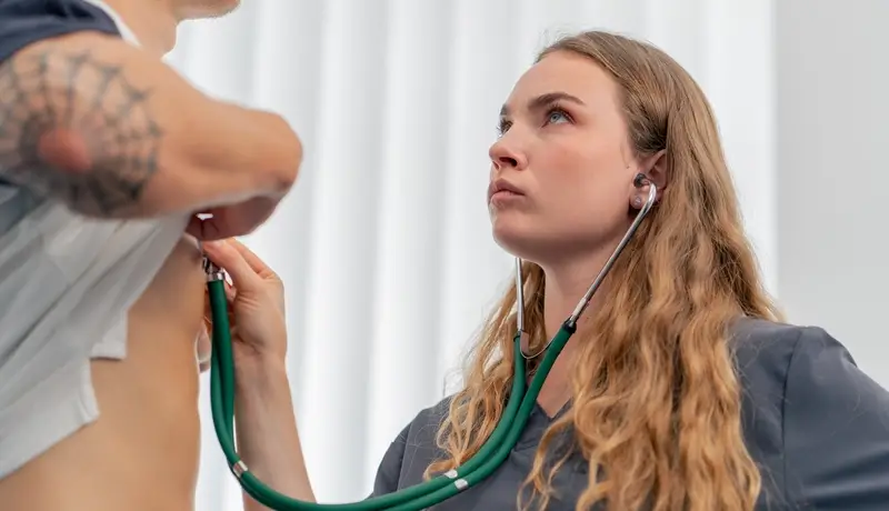 in a modern clinic in a small therapist s office, a young girl doctor with a stethoscope conducts an