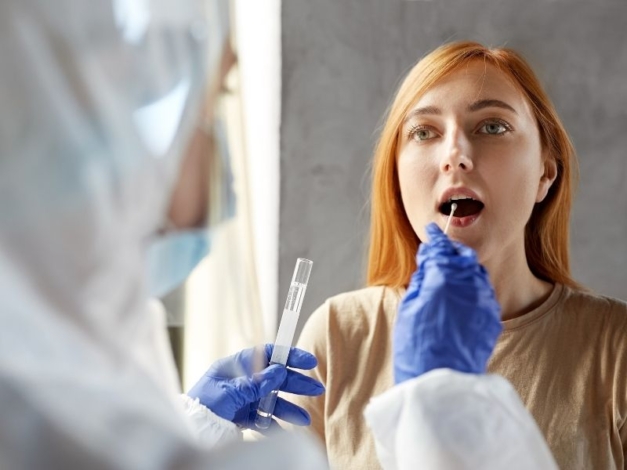 a doctor taking sample from a womans throat