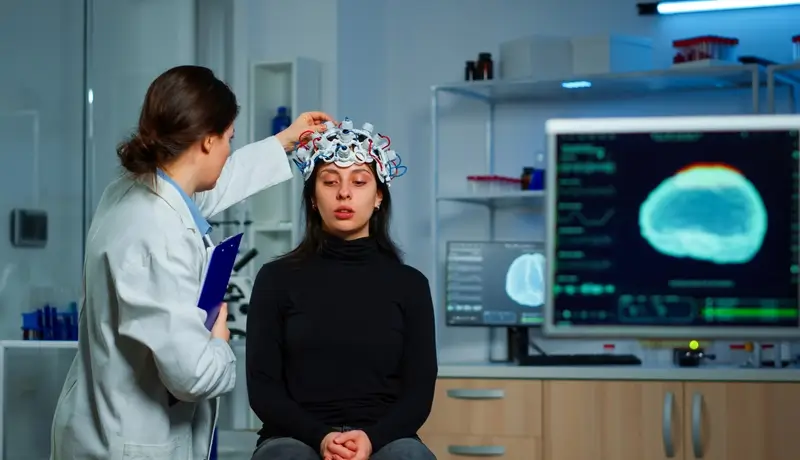 Neurological doctor cheking eeg headset explaining treatment