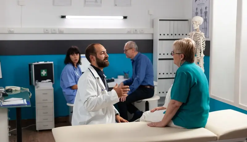 Patient with physical injury talking to doctor about recovery