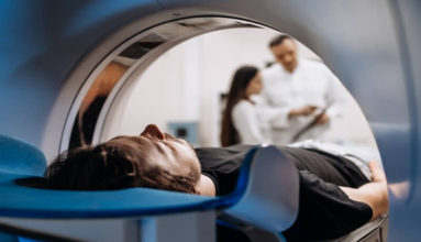 A man into a MRI scanner and far away from picture 2 doctors studying his results