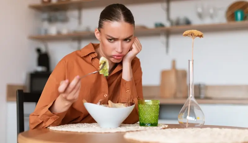 A woman having trouble on eating her food