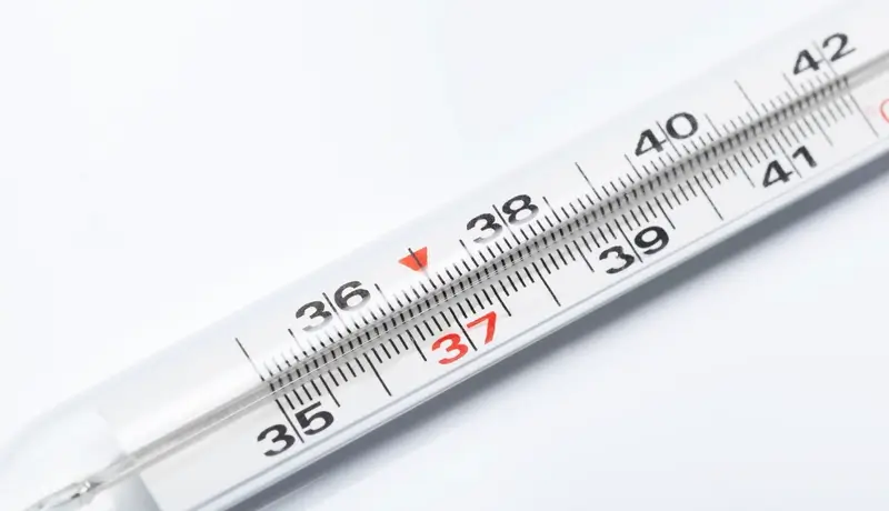 A traditional thermometer showing the normal body temperature of 37°C