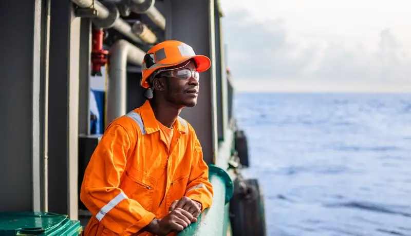 Tired Seaman AB or Bosun on deck of vessel or ship