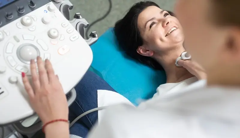 Woman undergoing a thyroid ultrasound examination